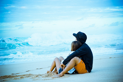 情侣坐在沙滩上浪漫一下