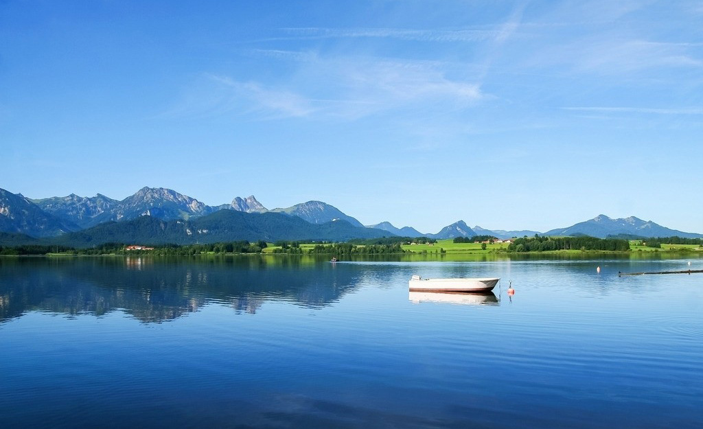 平静的湖面上飘着一叶小舟，美妙绝伦的自然风景