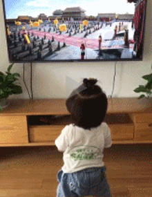 小女孩跟着电视里的场景跪拜皇上